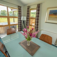A dining table with views  in a chalet at Loch Lomond Waterfront