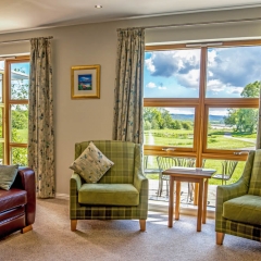 A lounge with a view in a lodge  at Loch Lomond Waterfront