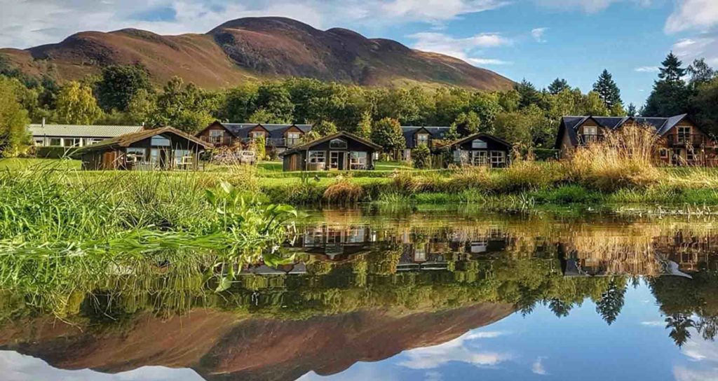 A view of the Loch Lomond Waterfront Lodges over still water