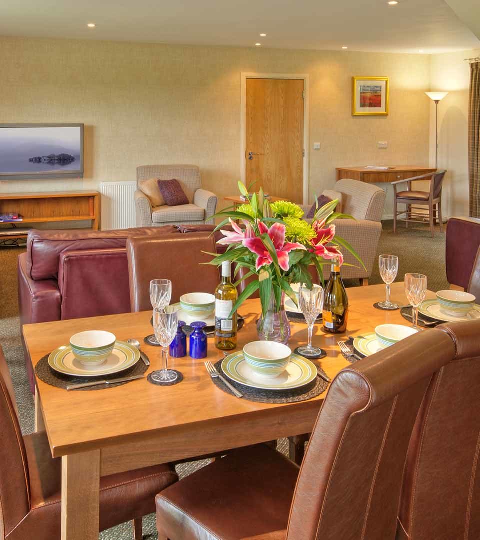 An open plan dining and living room in a lodge at Loch Lomond Waterfront