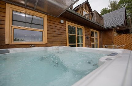 A hot tub outside a lodge at Loch Lomond Waterfront