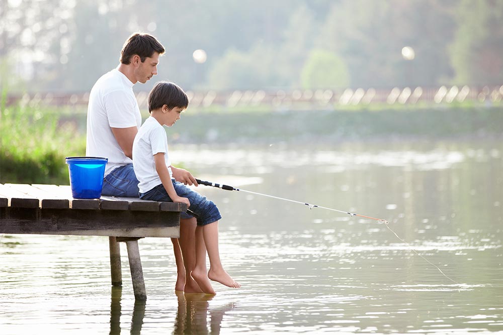 A father and son fishing off a pier