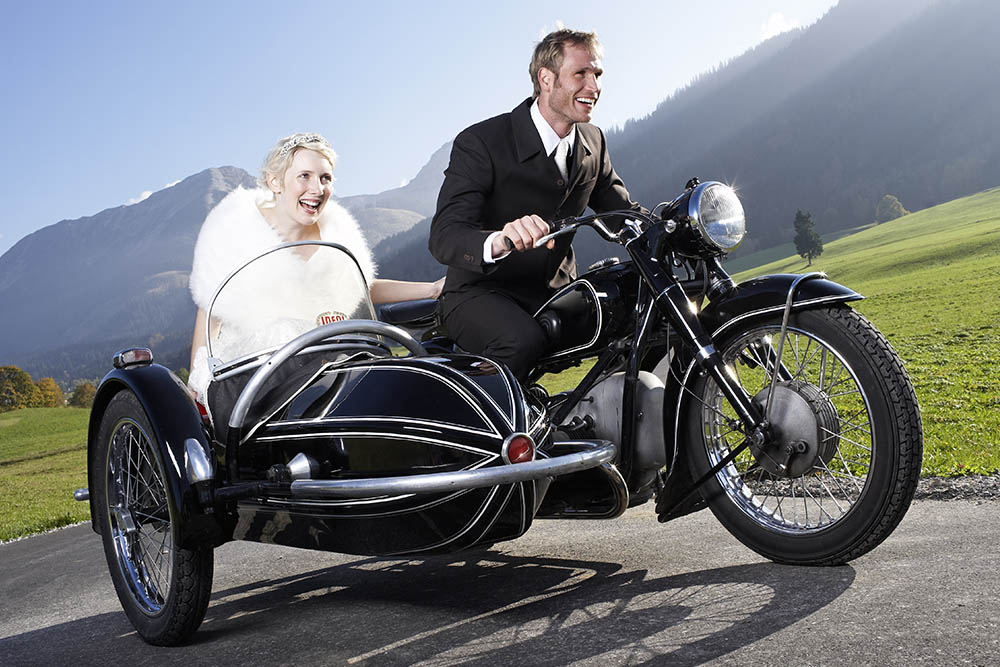 a bride and groom on a motorbike 