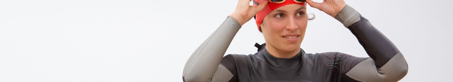 Outdoor swimmer in swim cap, goggles and wetsuit