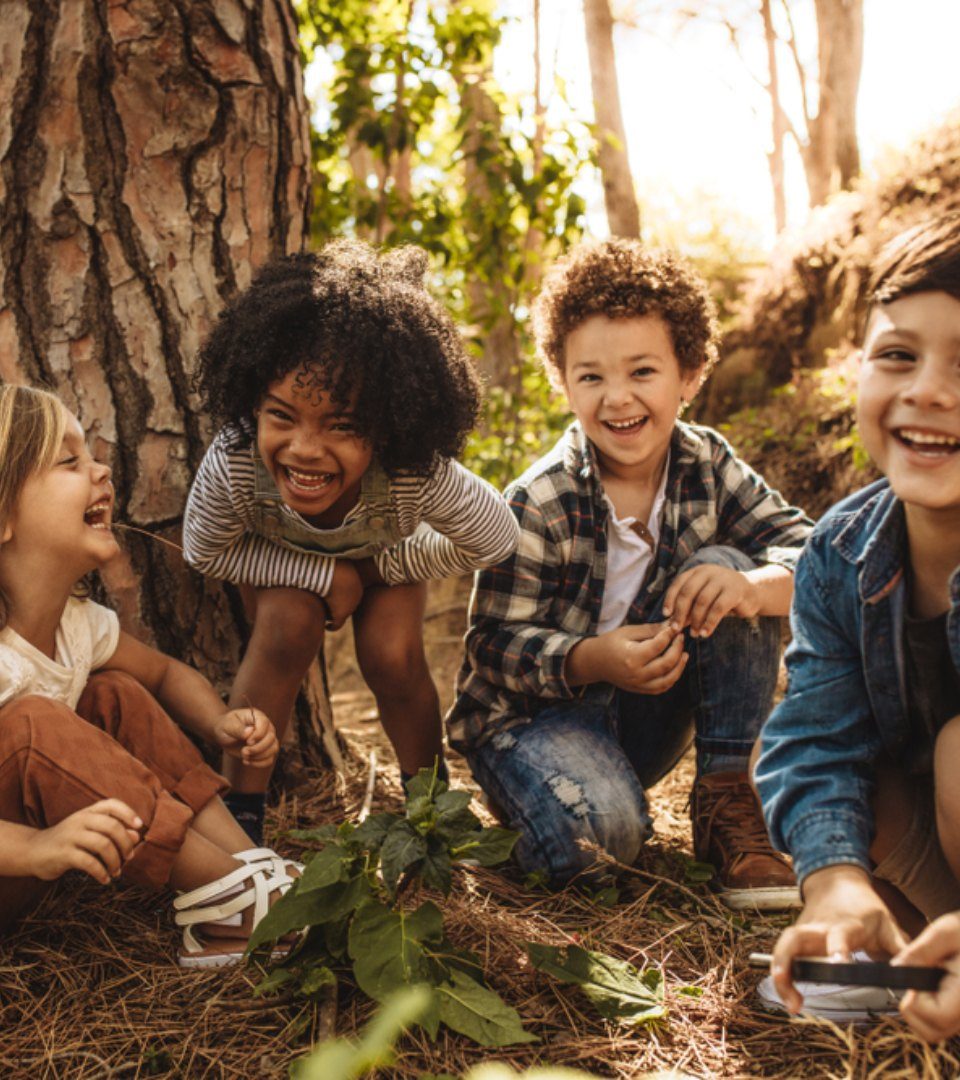 Four kids play in the woods at Loch Lomond on our Kids Go Free Special Deal