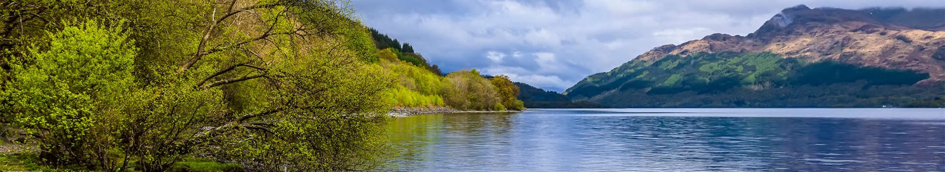 A view along shore of Loch Lomond in Scotland on a sunny day