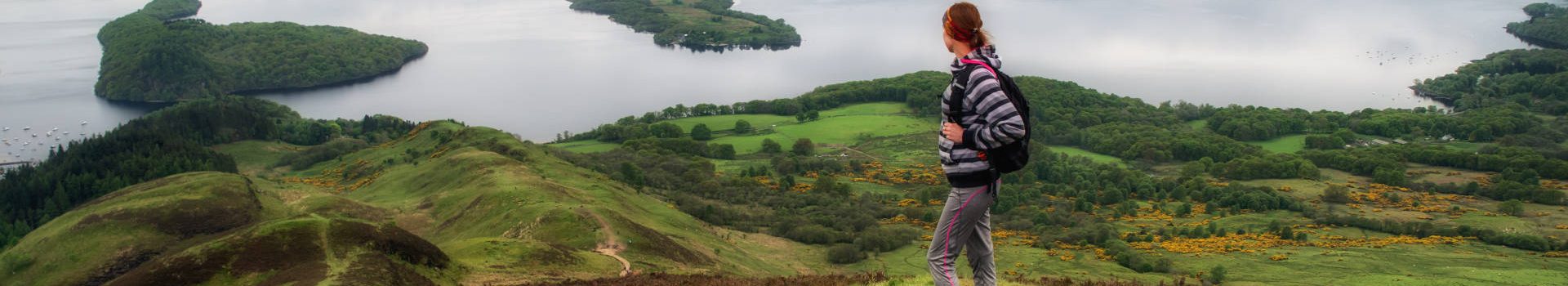 Walker looking at view of Loch Lomond from Conic Hill