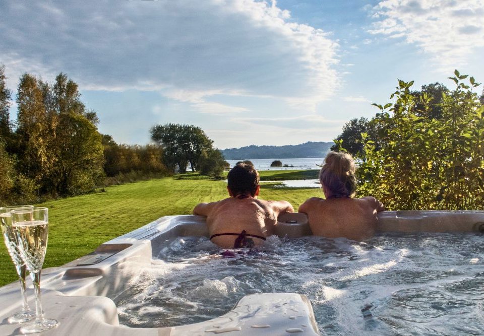 two women in a hot tub looking out at loch lomond
