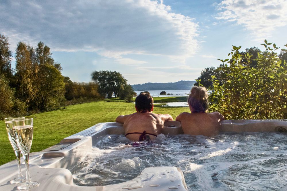 two women in a hot tub looking out at loch lomond