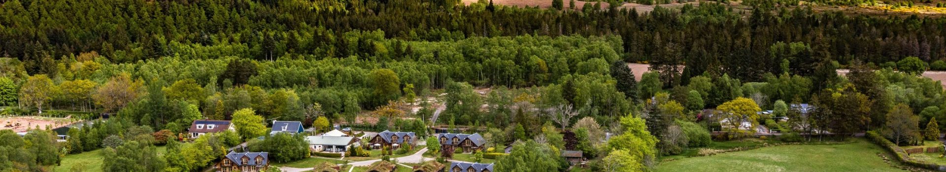 aerial view of loch lomond waterfront lodges with mountains in the background.