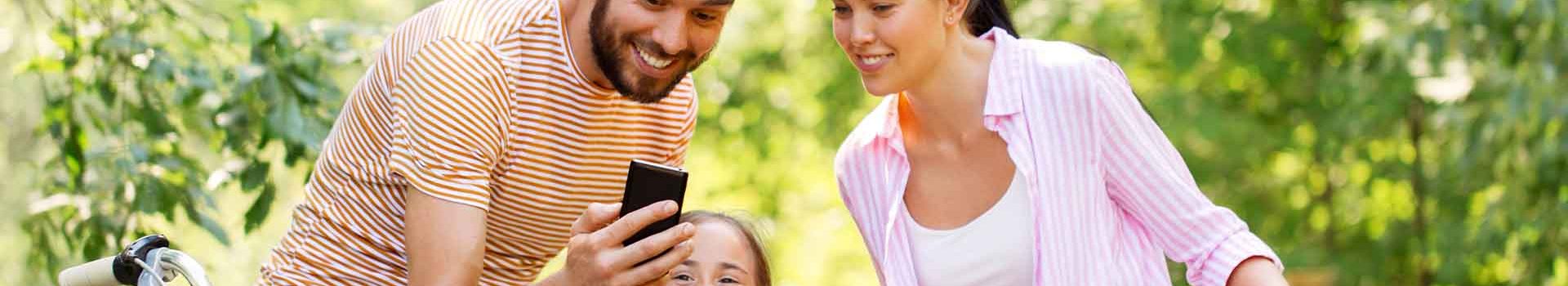 A family cycling and looking at an app on a phone.