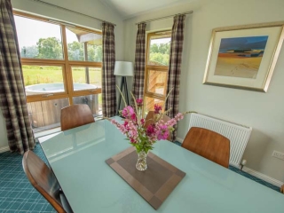 A dining table with views  in a chalet at Loch Lomond Waterfront