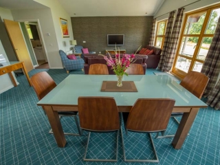 A dining area and living area  in a chalet at Loch Lomond Waterfront