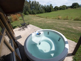 A hot tub on a patio outside  a chalet at Loch Lomond Waterfront