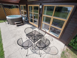 Patio table, chairs and a hot tub  outside  a chalet at Loch Lomond Waterfront