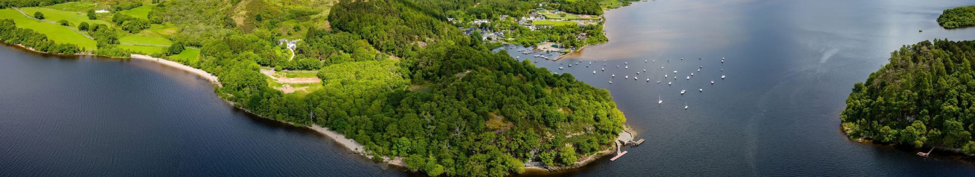 Panoramic aerial view of Conic Hill and Balmaha on the shores of Loch Lomond.