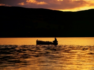 A fishermen fishing in the evening at Loch Lomond