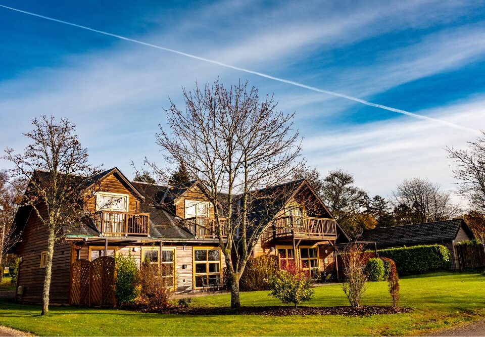 Loch Lomond Waterfront lodges on a sunny winters day with blue sky in the background.