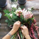 A bunch of beautiful flowers being arranged by a florist.