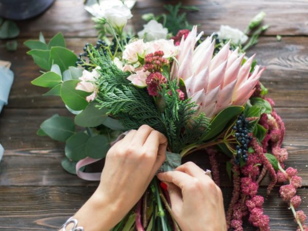 A bunch of beautiful flowers being arranged by a florist.