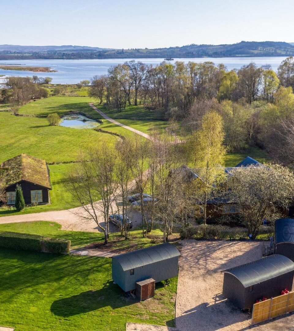 Drone photo of our glamping holiday huts by Loch Lomond and Conic Hill in Spring.