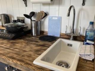 The kitchen worktop and utensils in a Shepherd&#039;s Hut at Loch Lomond Waterfront