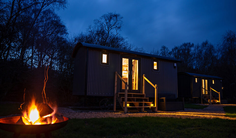 A Shepherd&#039;s Hut at Loch Lomond Waterfront with a campfire outside