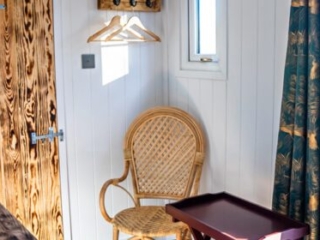 A table and chair in a a Shepherd&#039;s Hut at Loch Lomond Waterfront