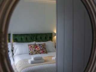A mirror reflecting a double bed in a Studio Lodge at Loch Lomond Waterfront