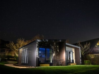 A Studio Lodge at Loch Lomond Waterfront lit up at night