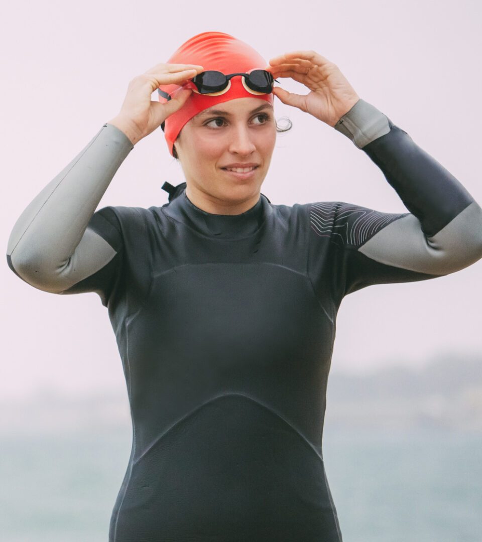 Outdoor swimmer in swim cap, goggles and wetsuit