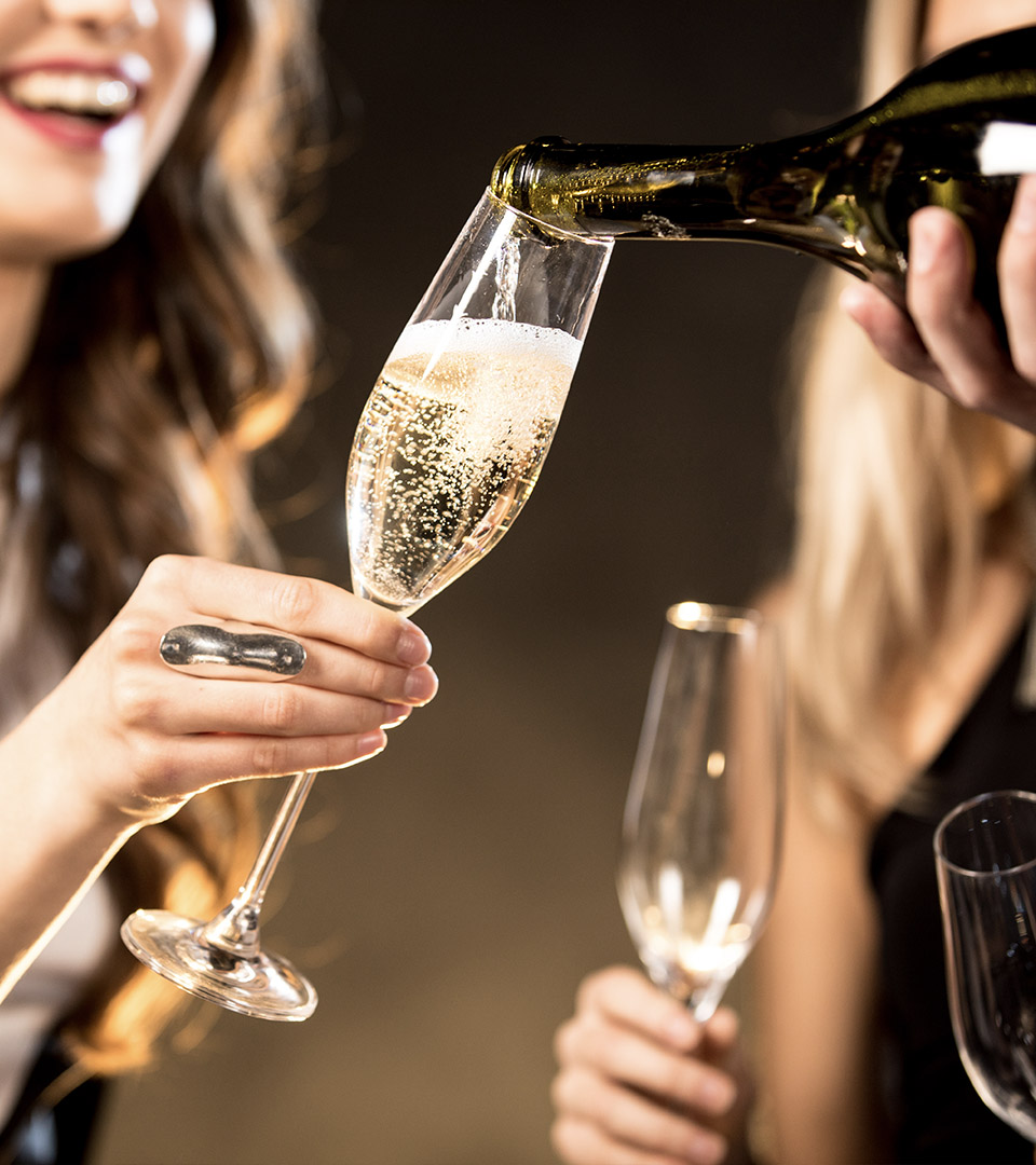 Prosecco being poured into a girls glass