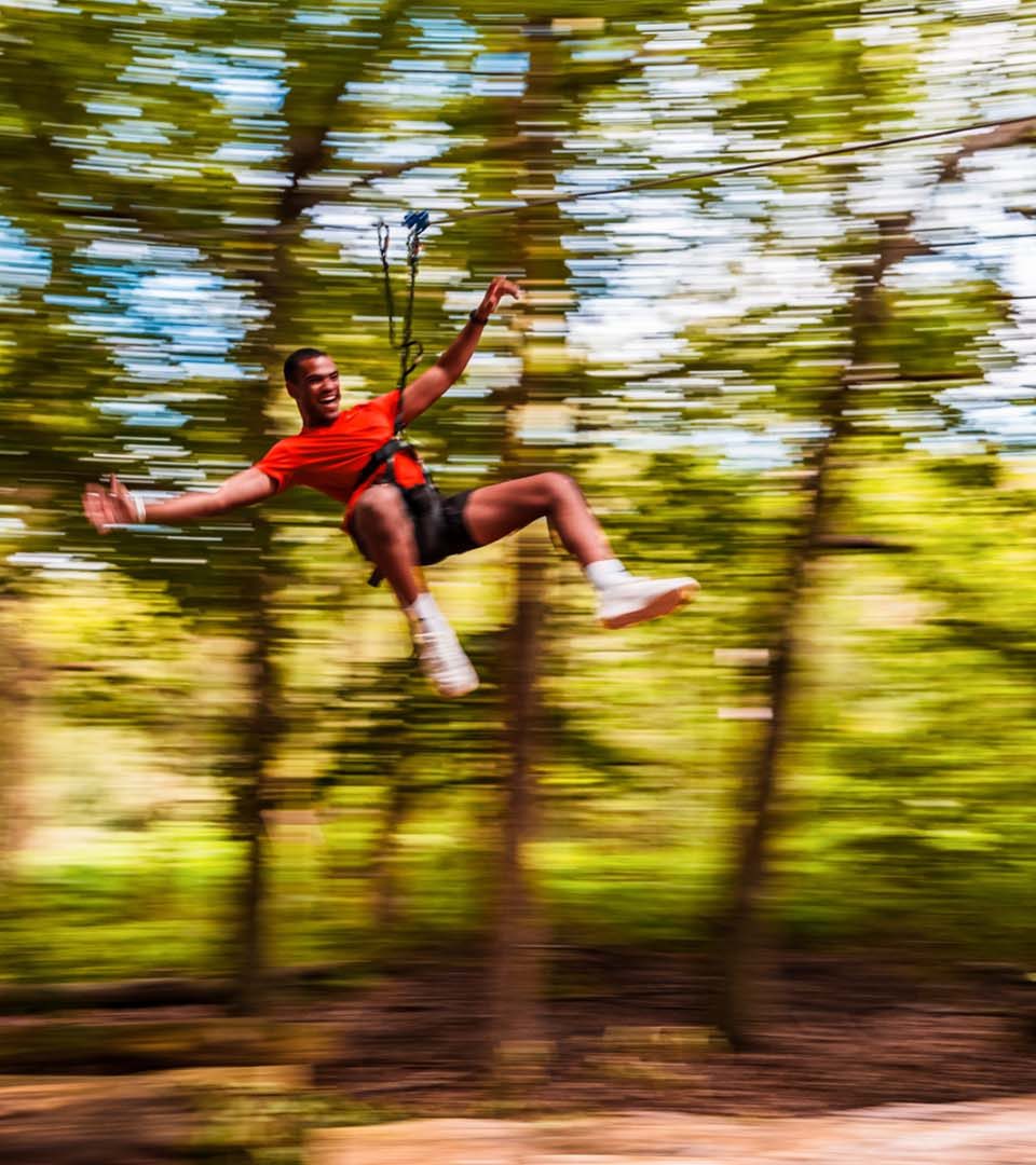 A man on a zip slide at Go Ape