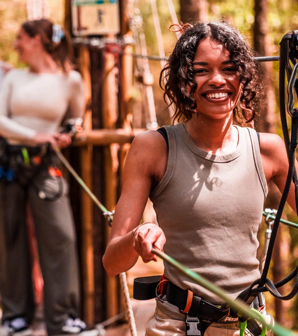 A girl walking a treetop zip wire suspension bridge at Go Ape