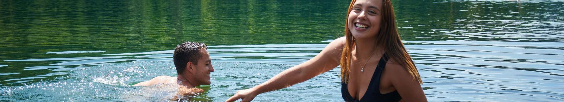 A couple wild swimming in a loch