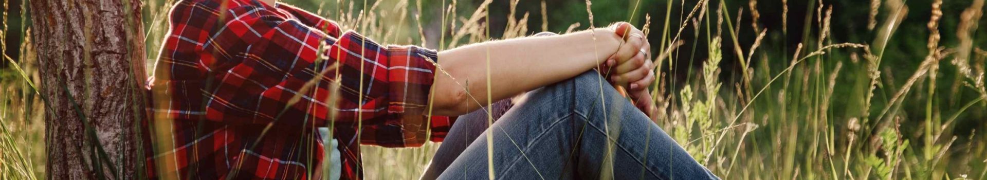 A woman relaxing by a tree